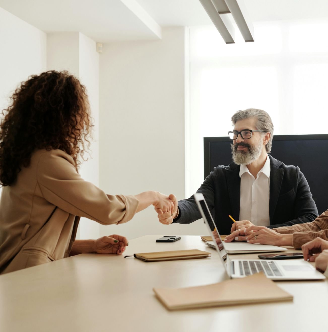 Handschlag zwischen Geschäftspartnern im Büro – Beginn einer erfolgreichen HR-Zusammenarbeit mit HRzlich